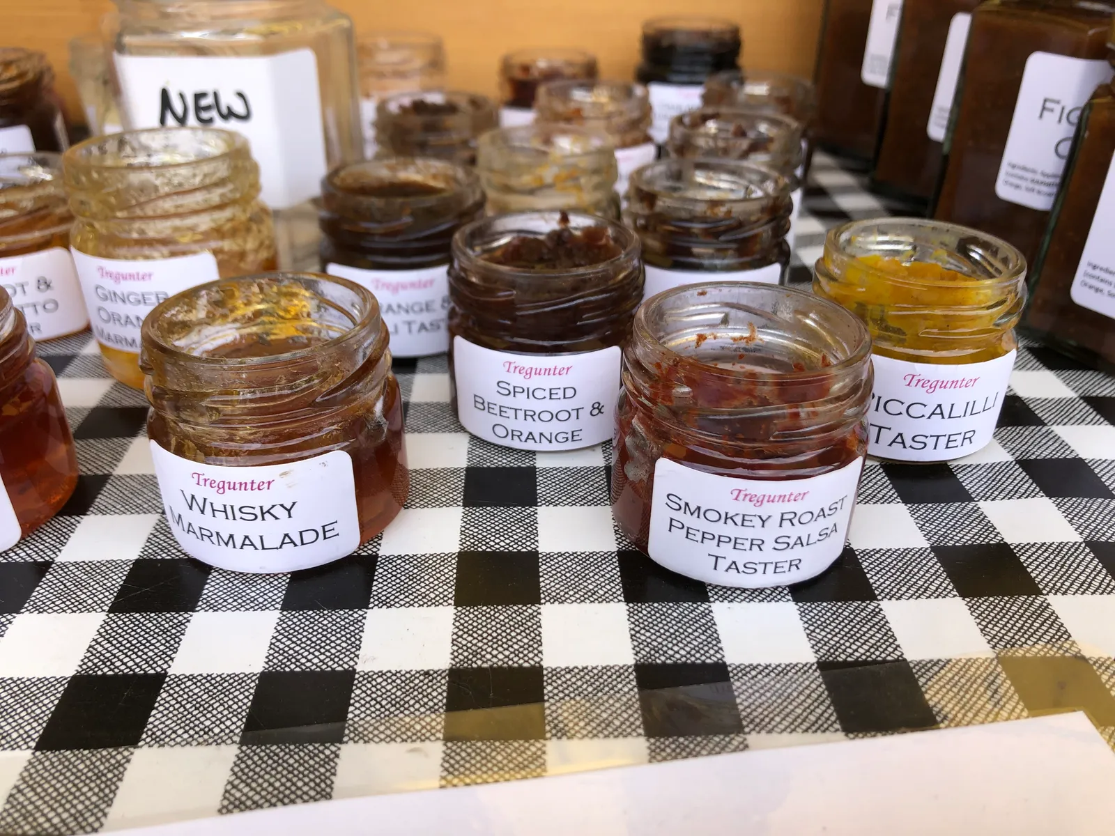 A tray of Tregunter taster jars on the market stall — whisky marmalade, spiced beetroot & orange, smokey roast pepper salsa and more.